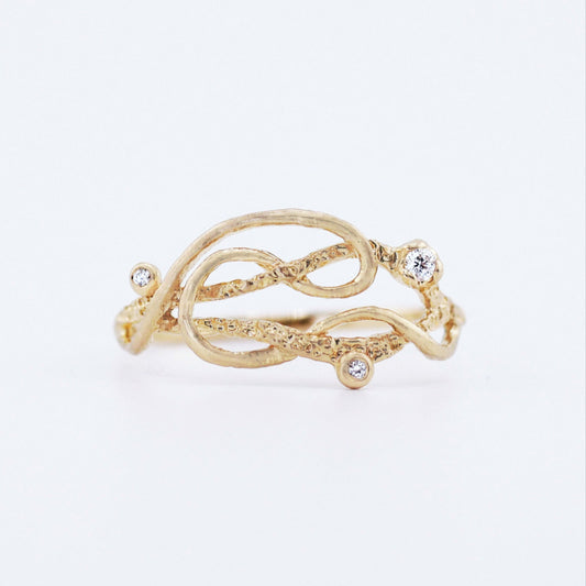 Intertwined gold ring with small diamonds, that looks like an Interstellar course.