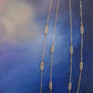Gold chain necklace on a textured blue background